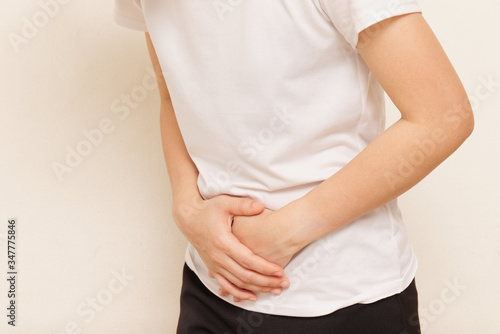 Wallpaper Mural Young woman suffering from stomach ache on gray background Torontodigital.ca