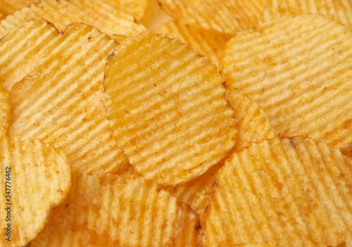 texture of round fried potato corrugated chips, full frame