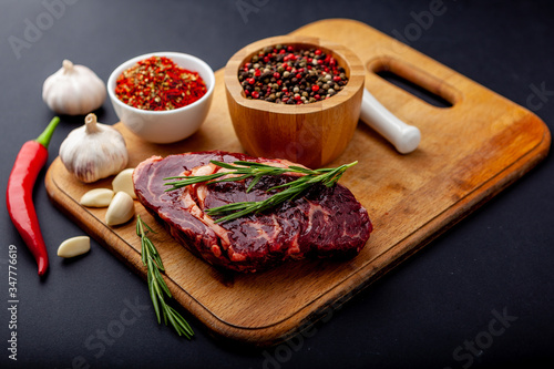 Fresh steak with a set of spices on a cutting board