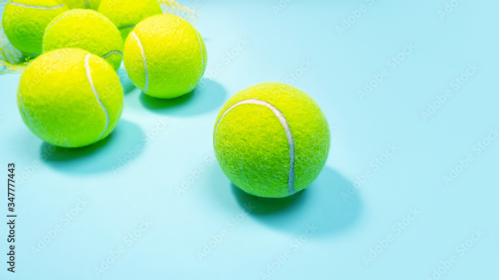 Tennis balls close up on blue hard tennis court. Copy space.