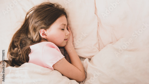 Adorable little girl sleep in the bed, copy space