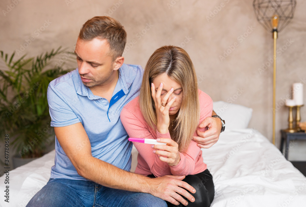 Sad couple looking at failed pregnancy test Sad couple looking at failed pregnancy test