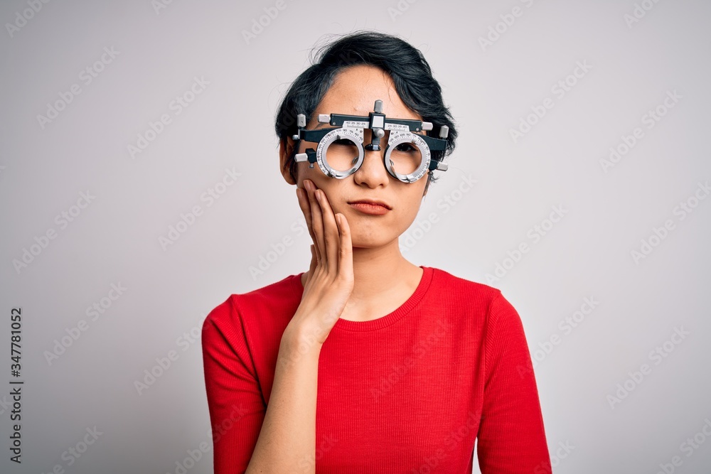 Young beautiful asian girl wearing optometry glasses standing over isolated white background thinking looking tired and bored with depression problems with crossed arms. Young beautiful asian girl wearing optometry glasses standing over isolated white background thinking looking tired and bored with depression problems with crossed arms.