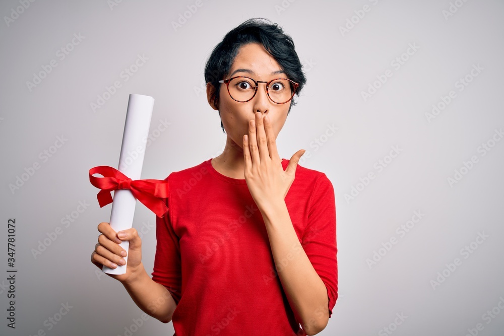 Beautiful chinese student woman wearing glasses holding university graduated diploma degree cover mouth with hand shocked with shame for mistake, expression of fear, scared in silence, secret concept Beautiful chinese student woman wearing glasses holding university graduated diploma degree cover mouth with hand shocked with shame for mistake, expression of fear, scared in silence, secret concept