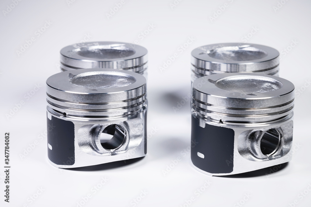New parts for the internal combustion engine. Pistons on a gray gradient background