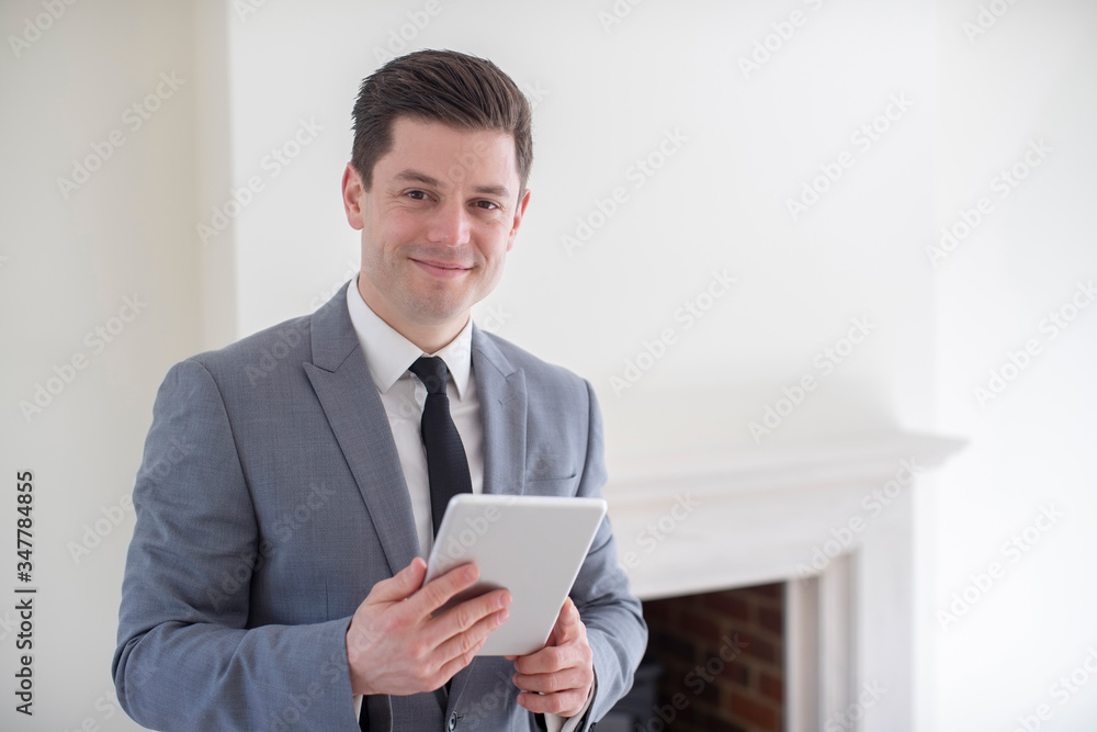Portrait Of Male Realtor With Digital Tablet Looking Around And Valuing New Home Portrait Of Male Realtor With Digital Tablet Looking Around And Valuing New Home