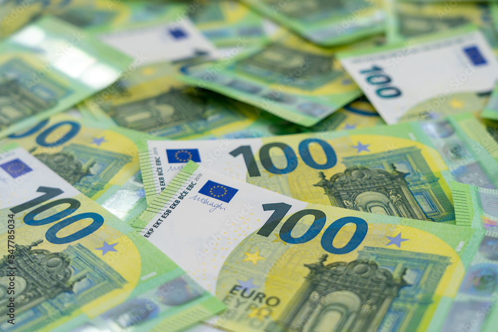 Banknotes of 100 hundred euros are scattered in a chaotic manner. European currency. Side view, close-up. Blank for design, background. Banknotes of 100 hundred euros are scattered in a chaotic manner. European currency. Side view, close-up. Blank for design, background.