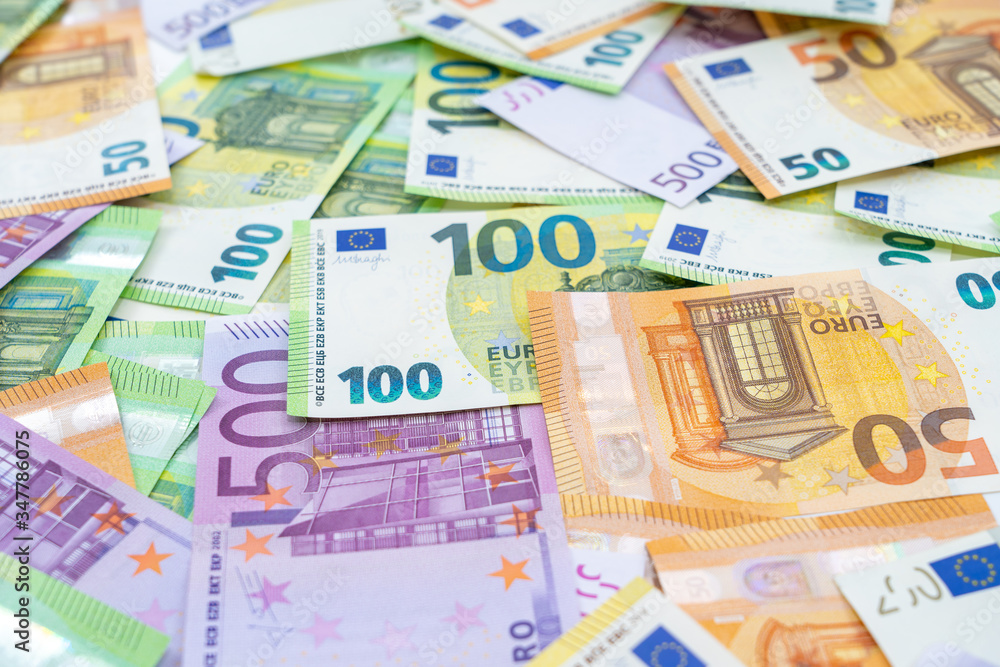 European currency lies on the table. Banknotes one hundred, two hundred, fifty, five hundred euros are scattered in a chaotic manner. Blank for design, background. Side view. European currency lies on the table. Banknotes one hundred, two hundred, fifty, five hundred euros are scattered in a chaotic manner. Blank for design, background. Side view.