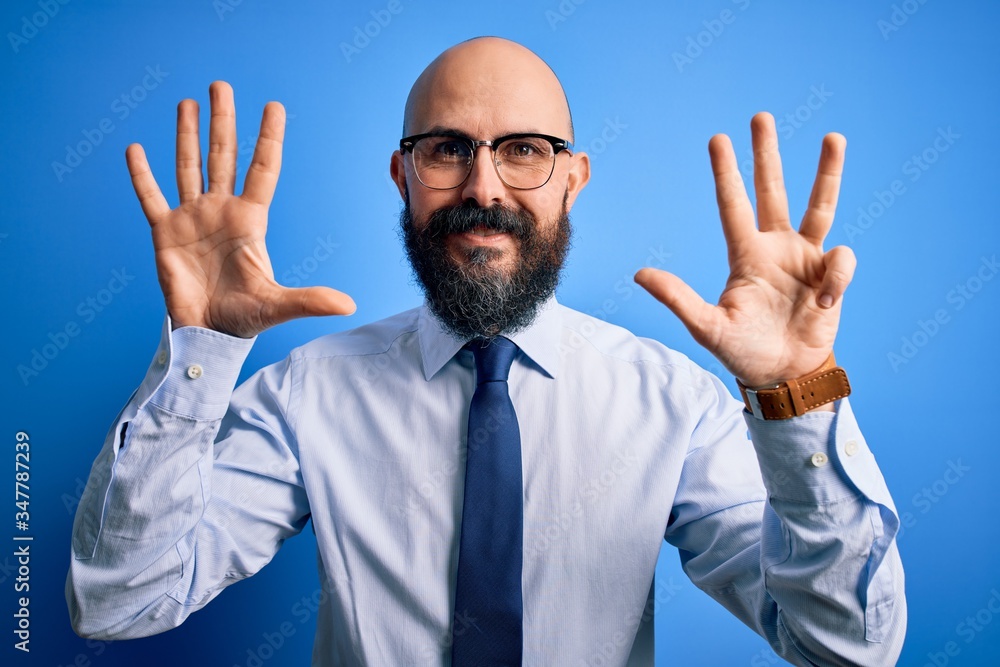 Handsome business bald man with beard wearing elegant tie and glasses over blue background showing and pointing up with fingers number nine while smiling confident and happy. Handsome business bald man with beard wearing elegant tie and glasses over blue background showing and pointing up with fingers number nine while smiling confident and happy.
