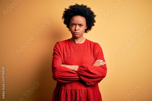 Young beautiful African American afro woman with curly hair wearing casual sweater skeptic and nervous, disapproving expression on face with crossed arms. Negative person. © Krakenimages.com