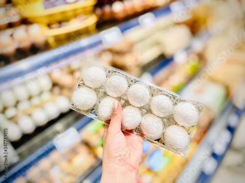 Hands hold a set of chicken eggs. Supermarket. Mobile photo.