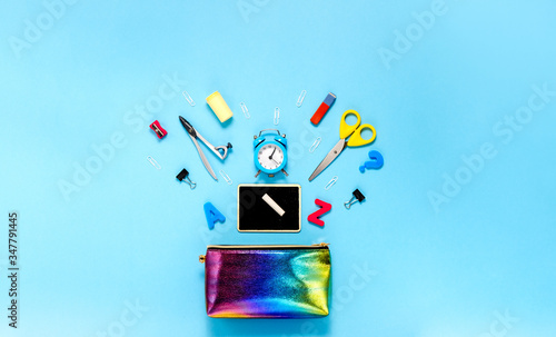 Back to school concept notepad, pencil case and stationery and school supplies. Top horizontal view copyspace blue background