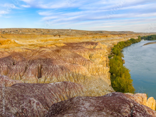 Colorful Rainbow Beach, or Wucaitan, Located along the Irtysh (Ertix) River in northern Xinjiang, a Yardang landscape carved from river bedrock by the dual action of wind abrasion by dust and sand photo