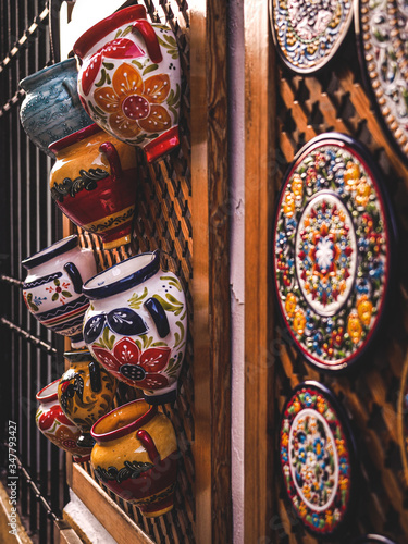 Colorful pots and plates for decoration hanging on a wall window shop in a street in the city of Cordoba, Spain photo