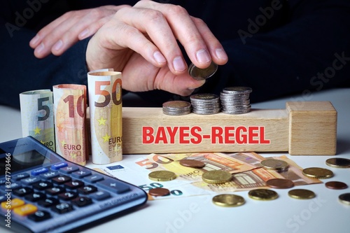 Bayes-Regel. Männliche Hand stapelt Geld-Turm (Euro). Begriff an Baustein. Münzen, Scheine & Taschenrechner. Konzept für Business, Finanzen, Statistik photo