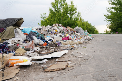 Heaps of trash on the road. Road and footpath full of rubbish / Dirty street / World Environment Day
