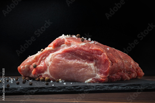 Φωτογραφία Raw pork chop steak on a black board. Pork antricot