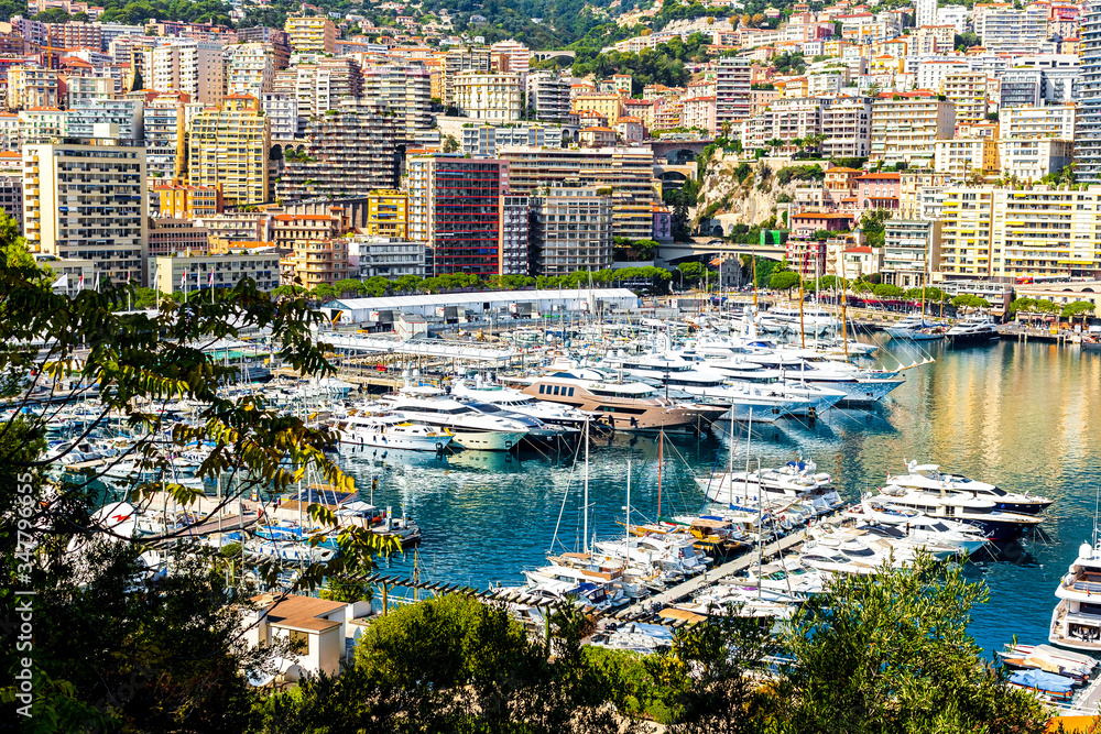 Monaco, Monte Carlo cityscape. Yachts moored at town quay In Sunny Summer Day. Panorama of the city of Monte Carlo. View of luxury yachts and apartments in the Harbor of Monaco, Cote d'azur.
