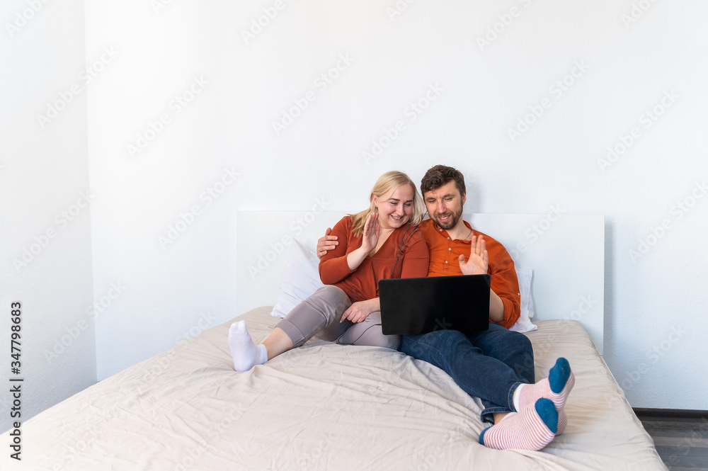 Smiling young adult couple using laptop and waving their hands motion blur effect Smiling young adult couple using laptop and waving their hands motion blur effect