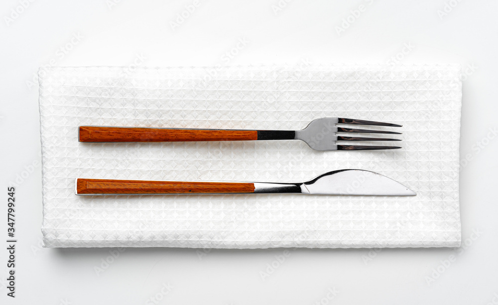 Set of fork and knife on towel. Isolated on white background. Close up. Set of fork and knife on towel. Isolated on white background. Close up.