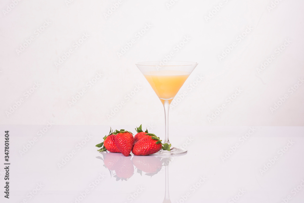 zumo de naranja natural en copa de cristal con fresas sobre fondo blanco zumo de naranja natural en copa de cristal con fresas sobre fondo blanco