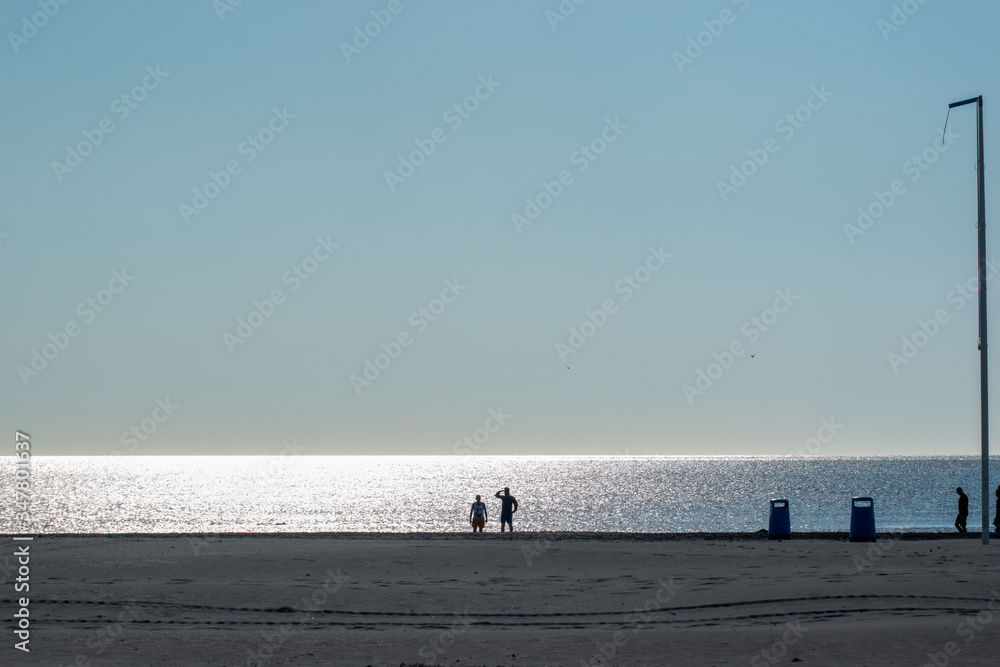 Sparkling sea,blue sky  silhouettes of people