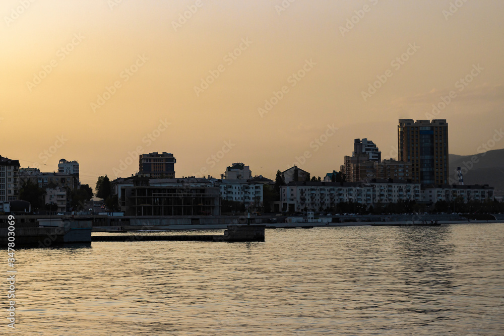 Novorossiysk, Krasnodar region / Summer sunset on the sea cost. City skyline in golden hour. 