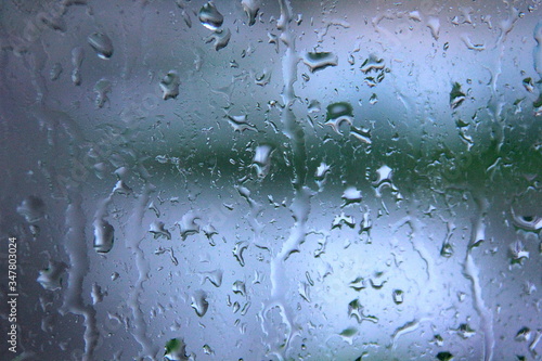 a rain-drenched window and the landscape out of focus behind it 2