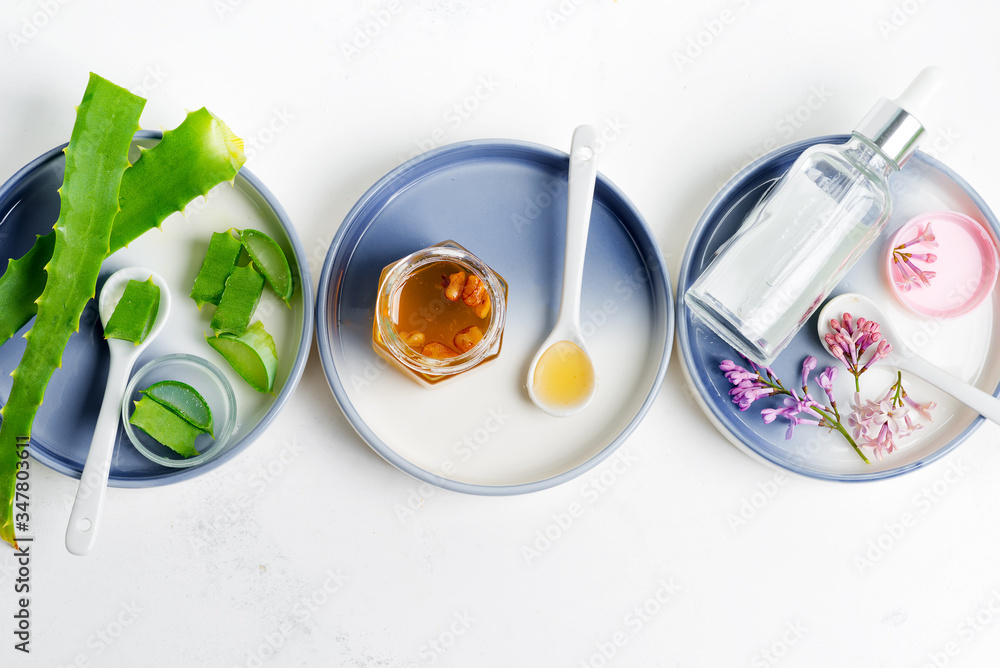 Natural ingredients for making cosmetic homemade lotion or essential oil on a light grey background. Natural ingredients for making cosmetic homemade lotion or essential oil on a light grey background.