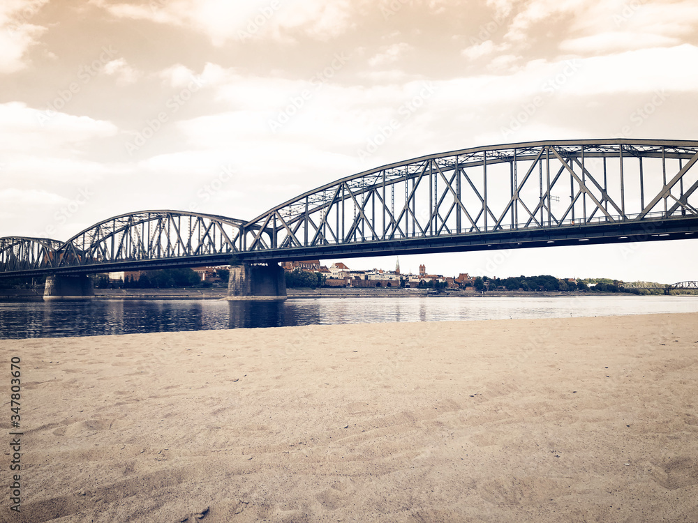 beautiful landscape of a European city metal bridge across the river near the beach