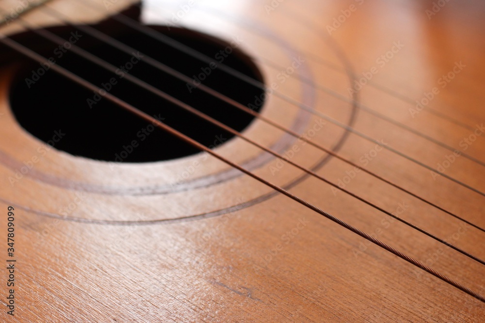 Obraz premium Sound hole of the guitar with the strings for the background.