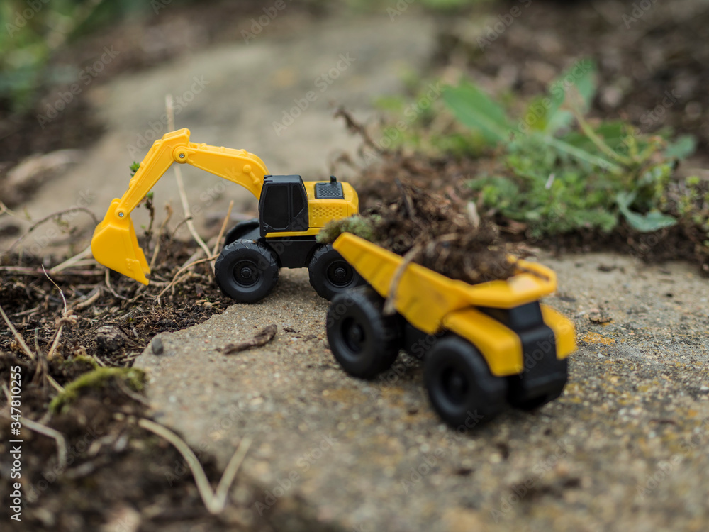 Toy construction machinery working on an excavation Toy construction machinery working on an excavation