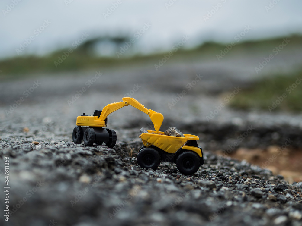 Toy construction machinery working on an excavation Toy construction machinery working on an excavation