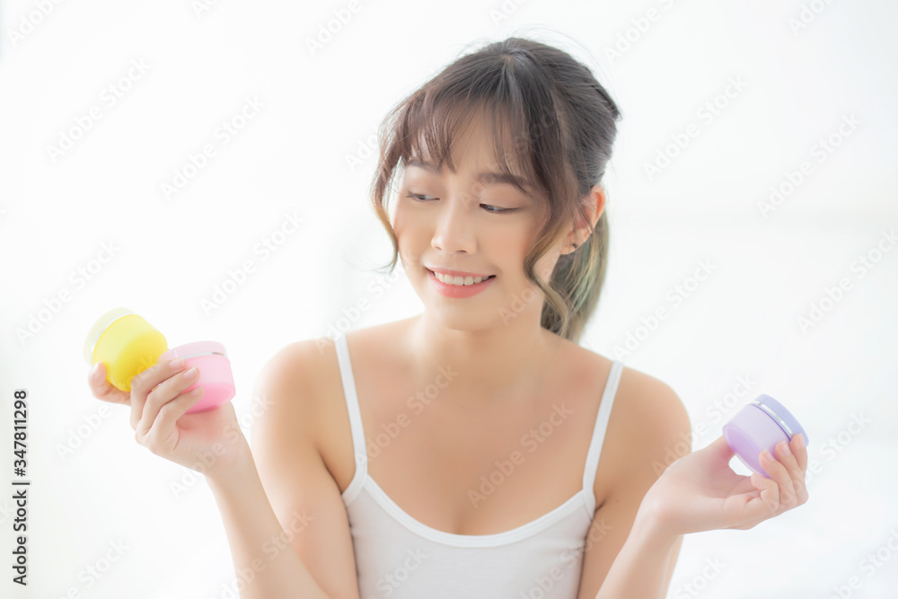 Beautiful portrait young asian woman holding and presenting cream or lotion product, beauty asia girl show cosmetic makeup and moisturizing for skin care, healthy care and wellness concept. Beautiful portrait young asian woman holding and presenting cream or lotion product, beauty asia girl show cosmetic makeup and moisturizing for skin care, healthy care and wellness concept.