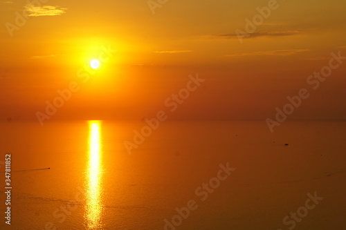Sunset over the Black sea on a spring day. It is striking with its purple colors. It is very romantic and beautiful. An ancient lighthouse is visible in the Golden rays. A man admires the setting sun.