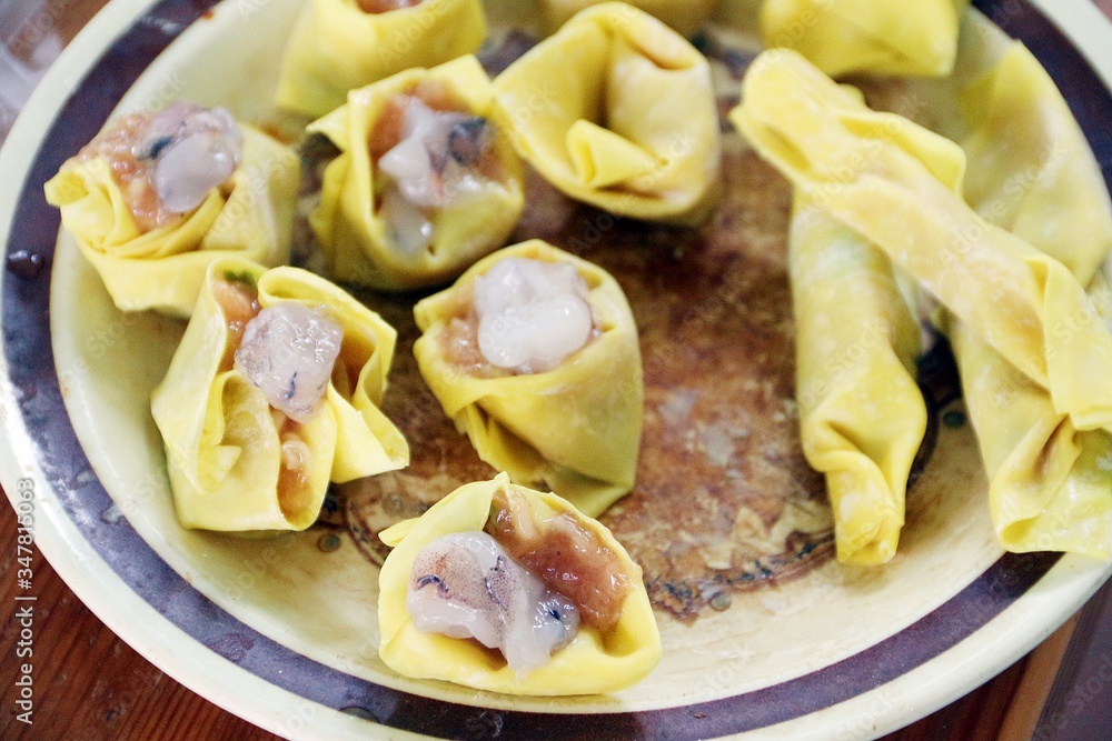 Raw home made dumplings made from shrimp and pork and wrapped by yellow flours before steam process Raw home made dumplings made from shrimp and pork and wrapped by yellow flours before steam process