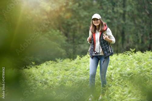 Young woman with backpack hiking in forest © goodluz