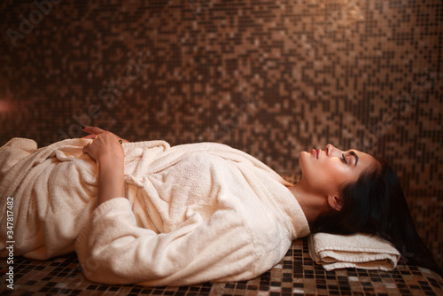 Foto Woman lying on a hot stone, turkish hamam, sauna