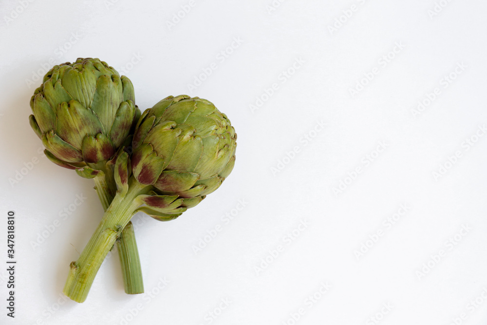Obraz premium Fresh green Italian Artichoke isolated on white background. Organic local produce vegetable on table top. Vegan diet. Clean eating concept. Close up, top view, flat lay.