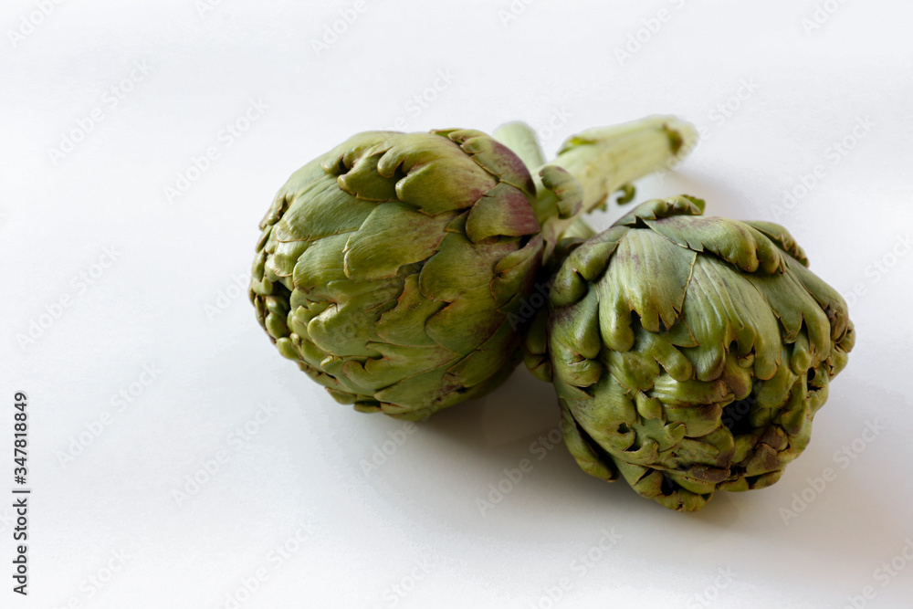 Obraz premium Fresh green Italian Artichoke isolated on white background. Organic local produce vegetable on table top. Vegan diet. Clean eating concept. Close up, top view, flat lay.