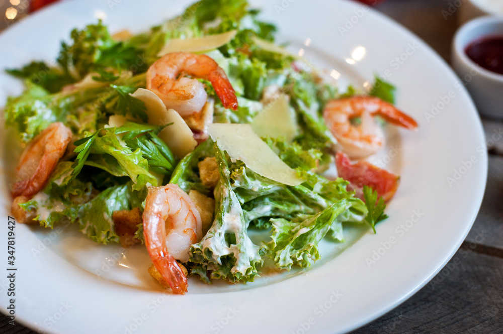 salad caesar with shrimps on white plate