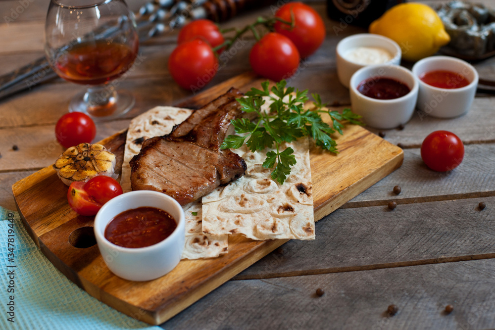Steak on the bone. Steak on a wooden Board with vegetables and herbs. The view from the top. Steak on the bone. Steak on a wooden Board with vegetables and herbs. The view from the top.