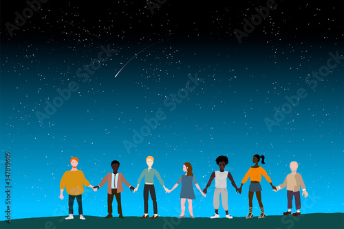 Together we are strong. A multinational group of people stand together holding hands against the starry sky. Epic concept