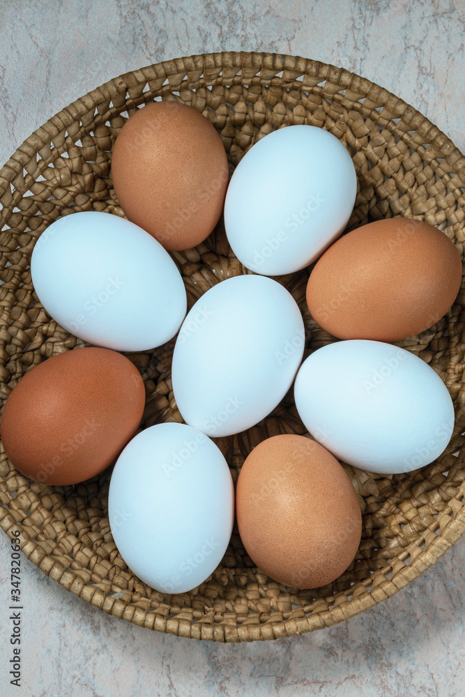 several fresh chicken eggs in a straw basket on a wooden background. Healthy eating concept. several fresh chicken eggs in a straw basket on a wooden background. Healthy eating concept.