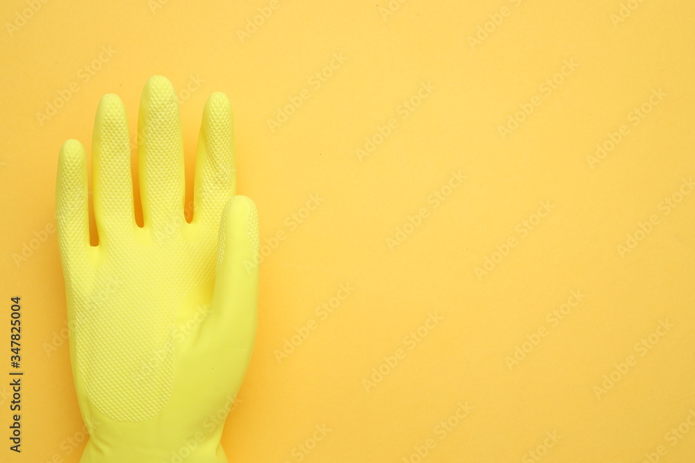 Hand in yellow glove isolated on yellow background,top view Hand in yellow glove isolated on yellow background,top view