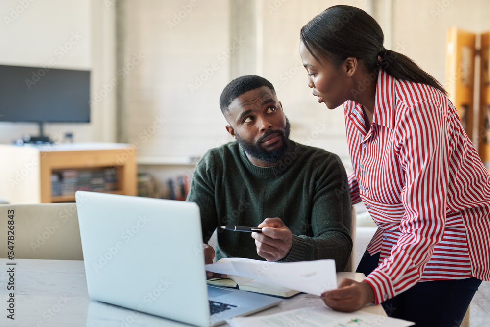 Obraz premium Young African American couple doing some online banking at home