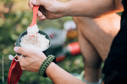 Tourist eats food in the summer forest. Outdoor recreation. photo