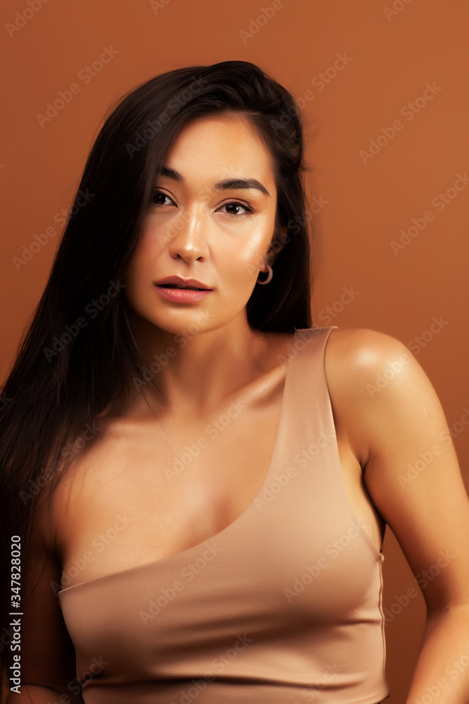 young pretty asian woman cheerful smiling posing on warm brown background, lifestyle people concept young pretty asian woman cheerful smiling posing on warm brown background, lifestyle people concept
