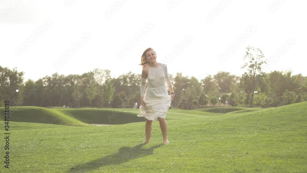 Beautiful girl in a white dress jumping and spinning in nature. Wind develops hair. Beautiful girl in a white dress jumping and spinning in nature. Wind develops hair.