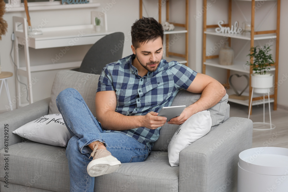 Young man with tablet computer at home